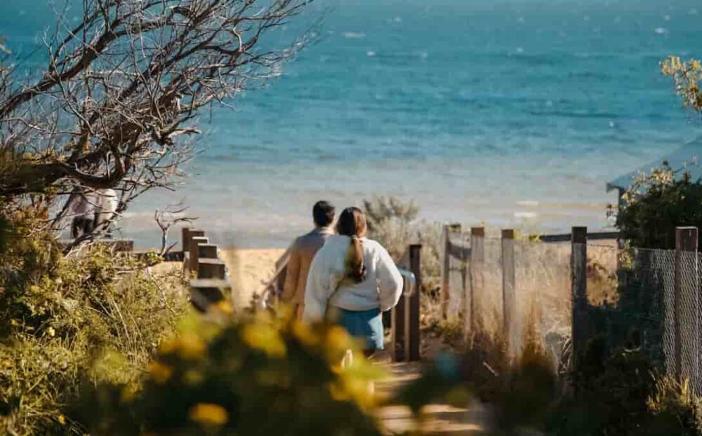 Couple walking down a path to the beach, ideal thumbnail for a real estate video.